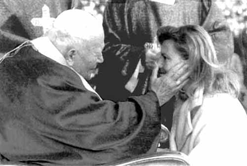 John paul II touching the cheek of a woman